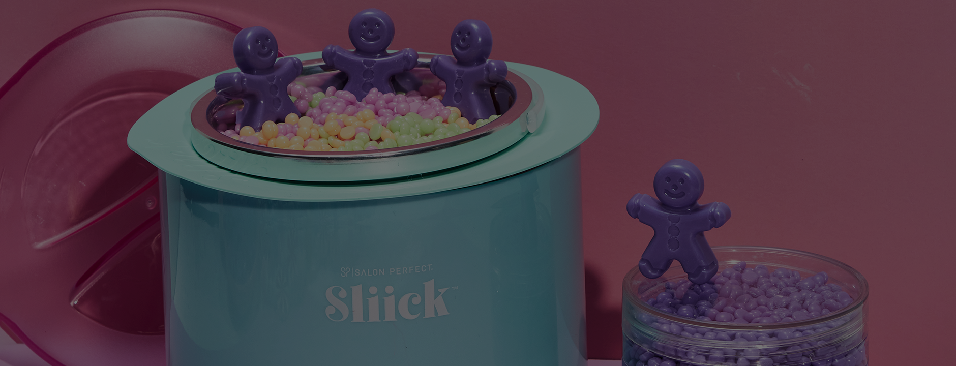 Slick wax warmer with small purple ginger bread waxes on a pink background