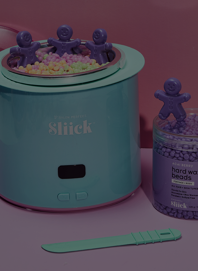 Slick wax warmer with small purple ginger bread waxes on a pink background