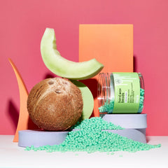 Sliick Coconut Melon Wax Beads – Spilled from an open jar, styled with coconut & melon slices on a bold pink & orange geometric backdrop.
